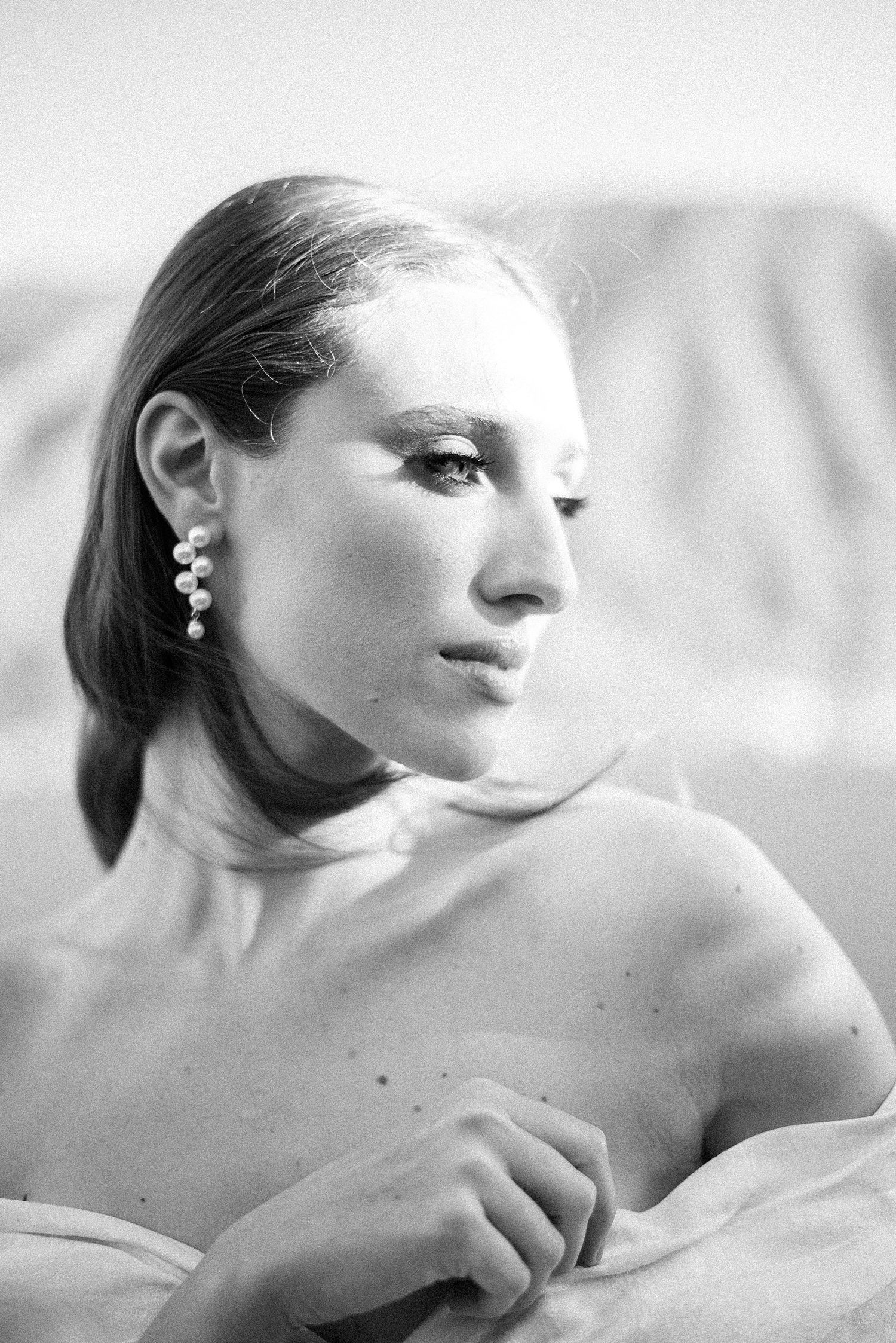 black and white portrait of bride looking over shoulder in strapless wedding gown 