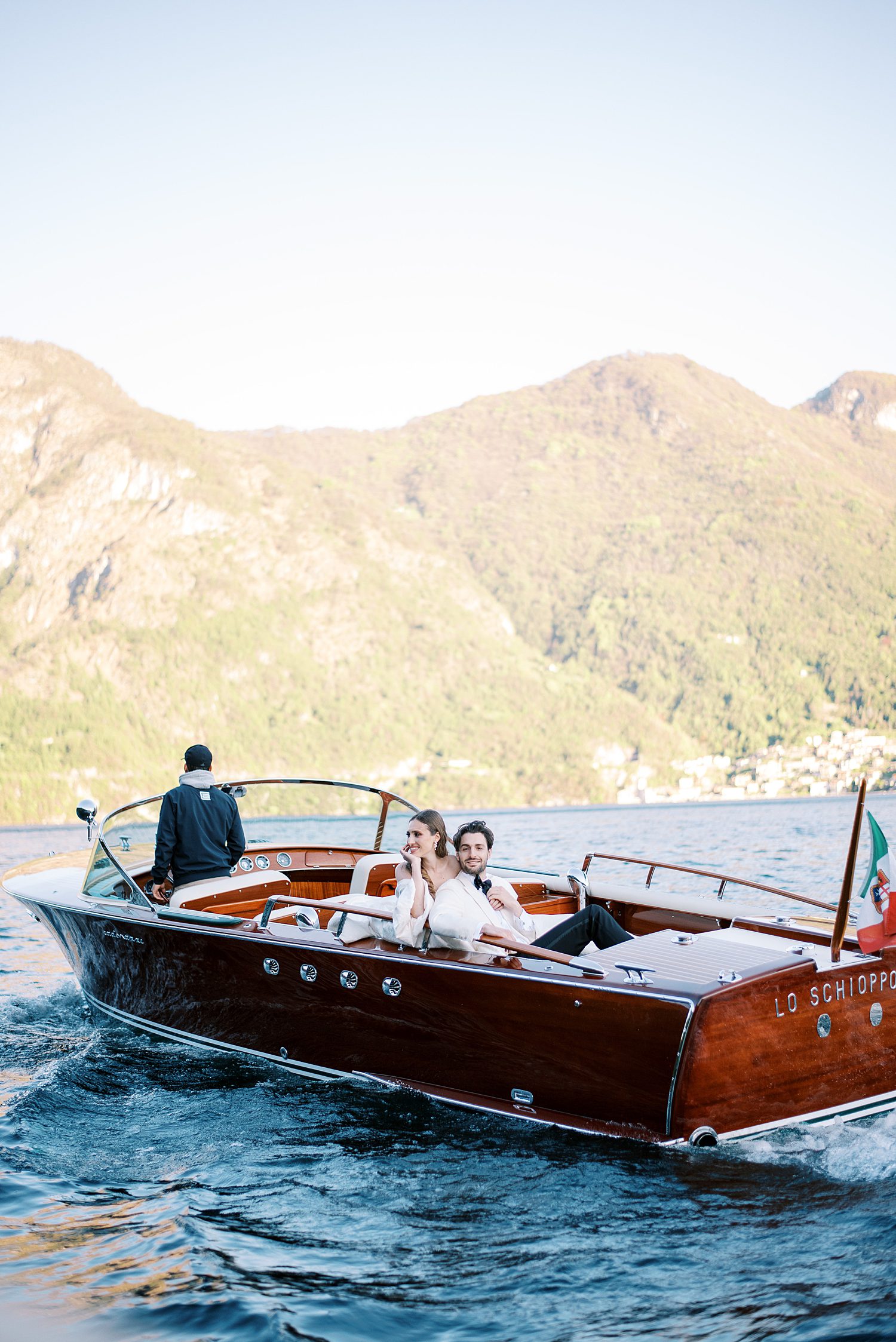 newlyweds ride in boat on Lake Como