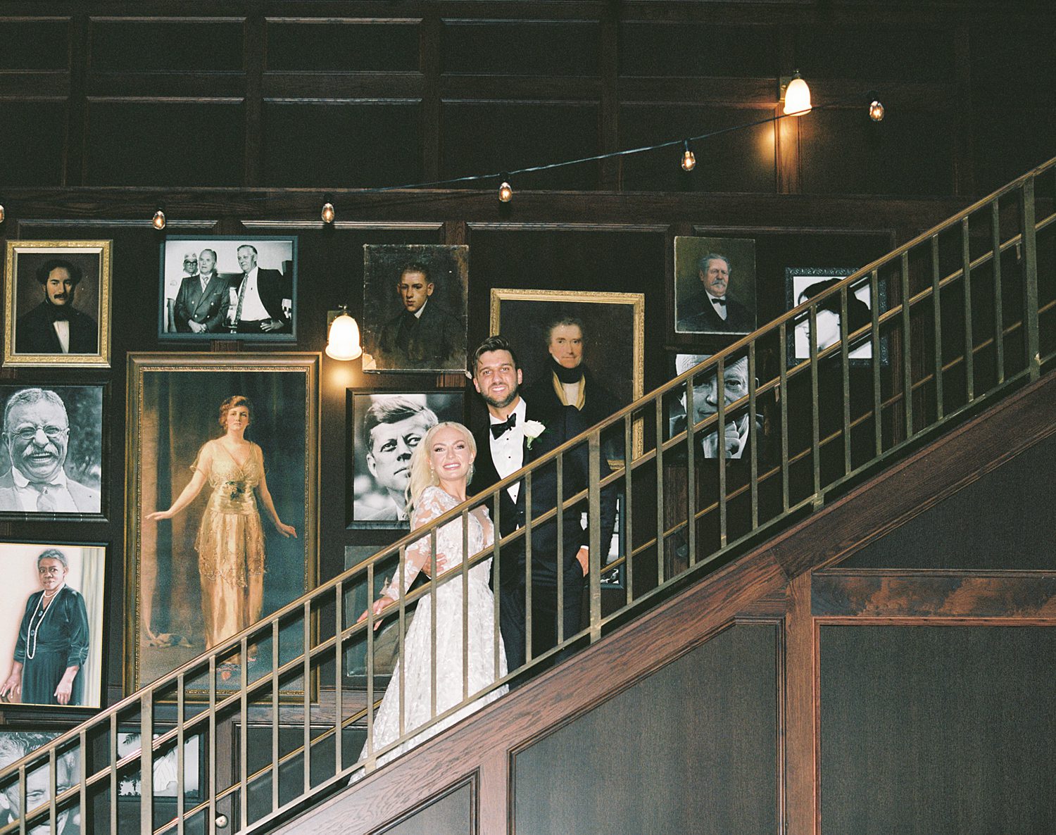 bride and groom stand on main staircase inside the Oxford Exchange