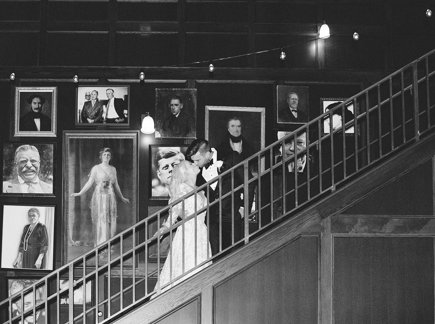 black and white photo of bride and groom on staircase inside the Oxford Exchange