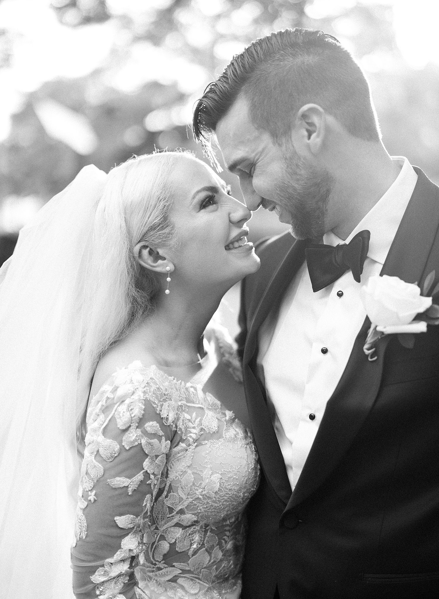 black and white photo of bride and groom leaning heads together 