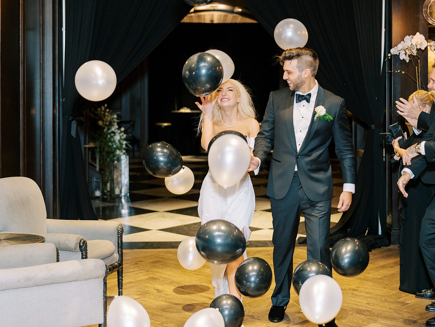 black and white balloons fall over bride and groom at the Oxford Exchange
