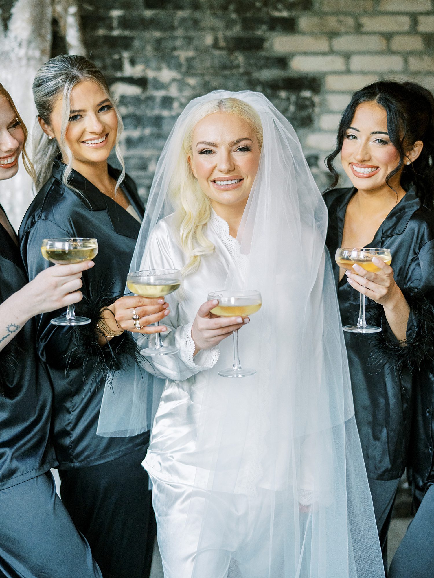 bride and bridesmaids hold custom cocktails in matching pajamas 