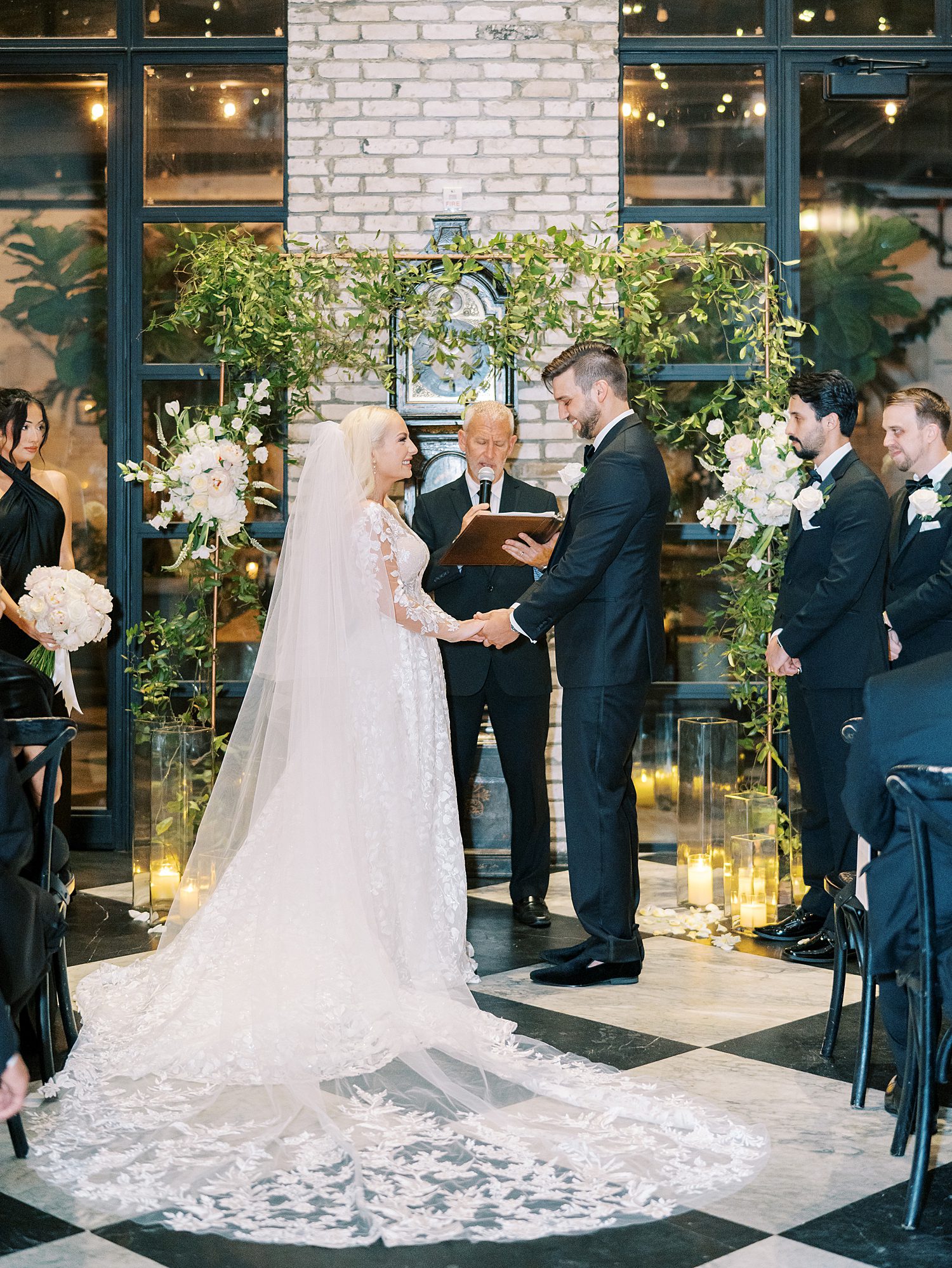 bride and groom hold hands during ceremony inside the Oxford Exchange