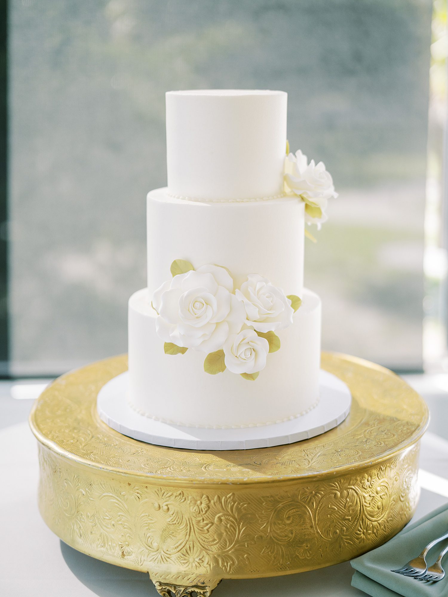 tiered wedding cake with ivory flowers on the tiers 