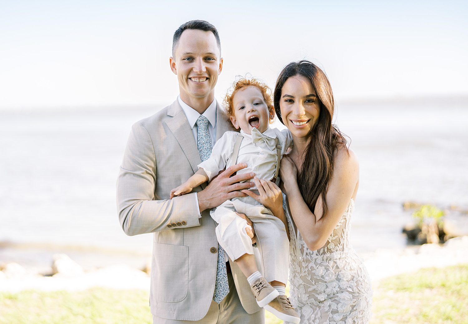 bride and groom pose with son on Tampa wedding day