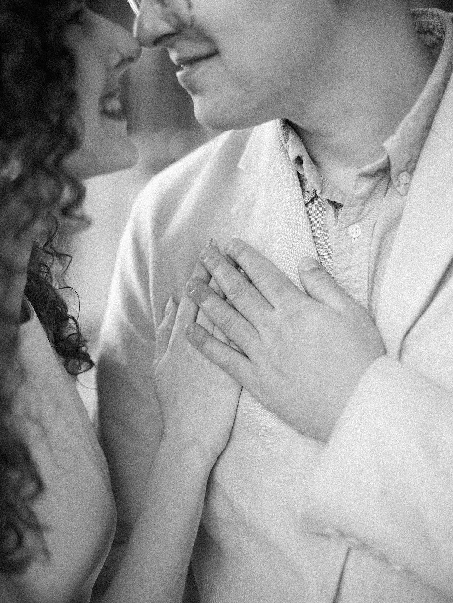 man and woman hold hands on man's chest during University of Tampa engagement photos