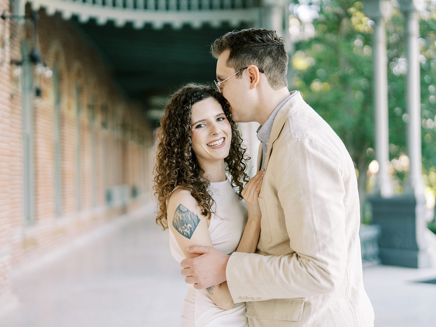 man kisses woman's forehead under walkway at the University of Tampa 