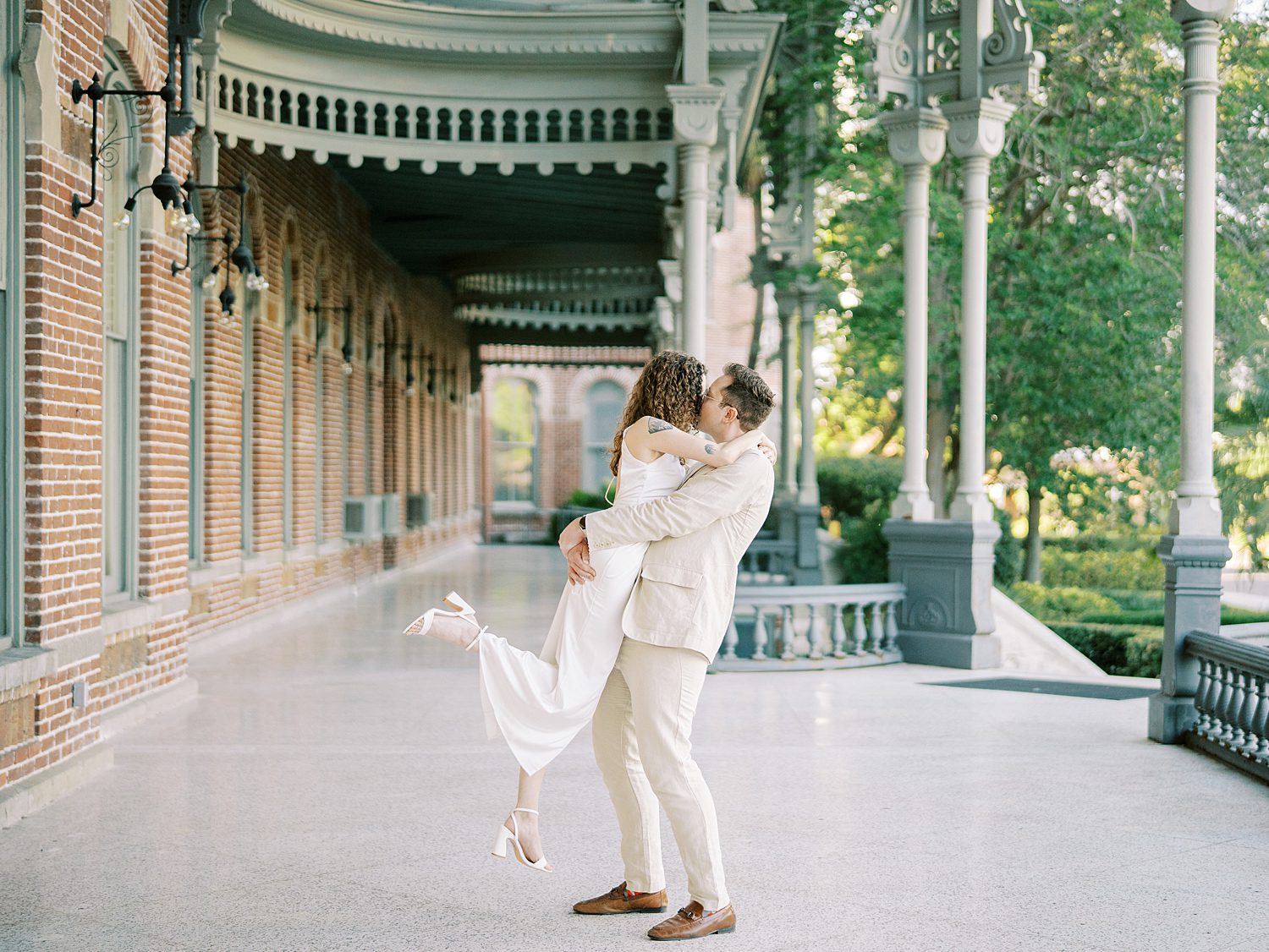 man kisses fiancee and lifts her up at the University of Tampa