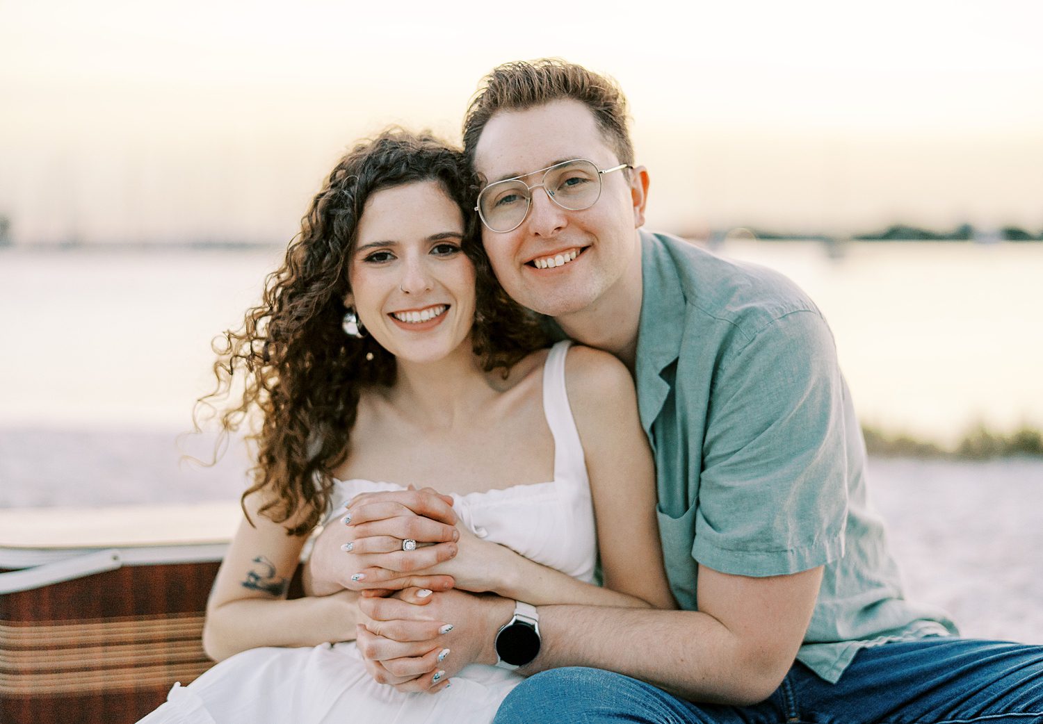 couple snuggles on blanket during engagement photos on Davis Island Beach