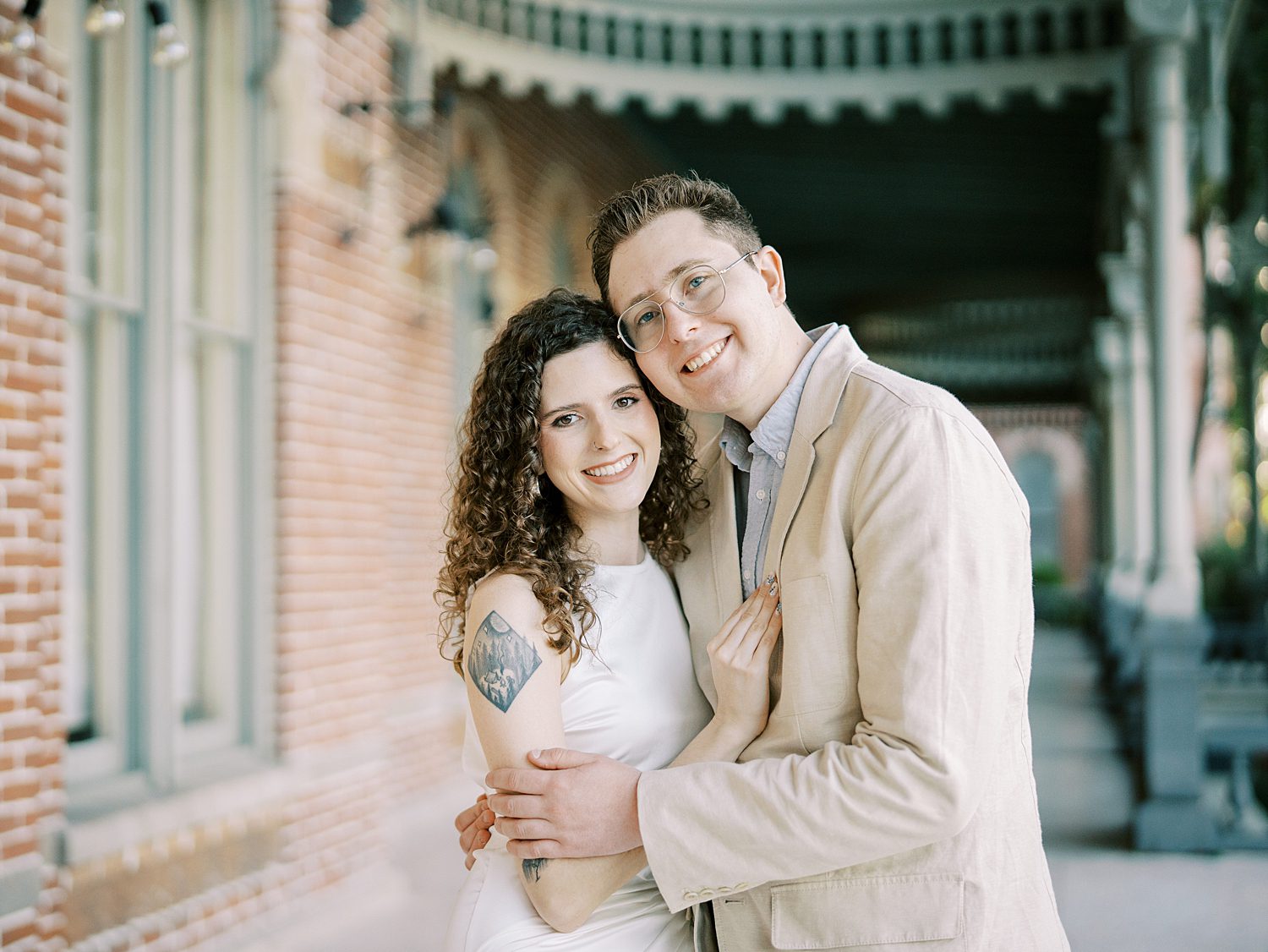 man and woman hug on porch of University of Tampa building 