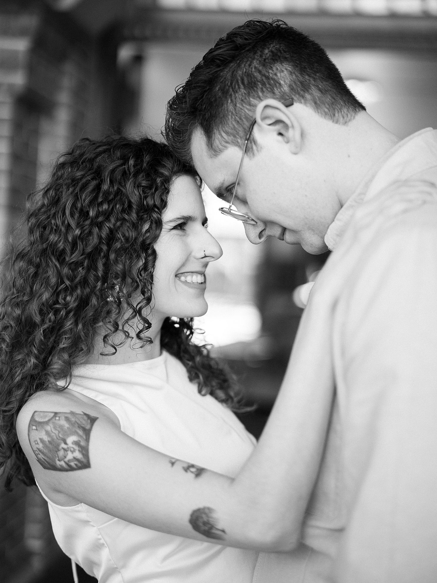 engaged couple leans heads together laughing during Tampa engagement photos 