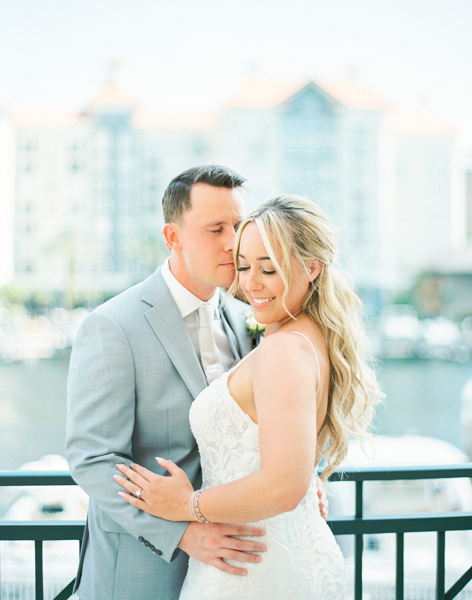 groom nuzzles bride's ear during portraits on balcony at Armature Works