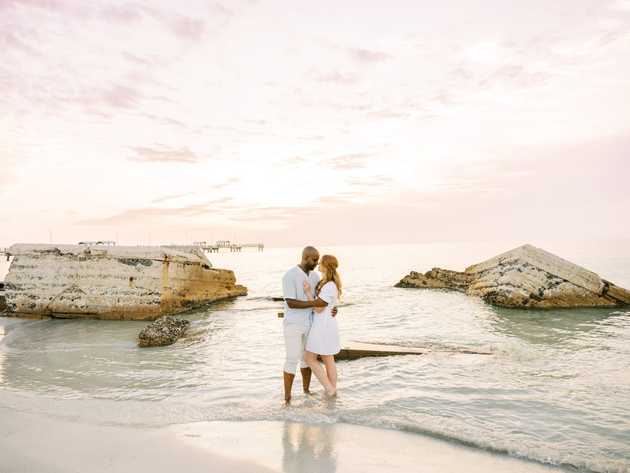 Fort de soto beach engagement session Beach with rocks and pier at sunset