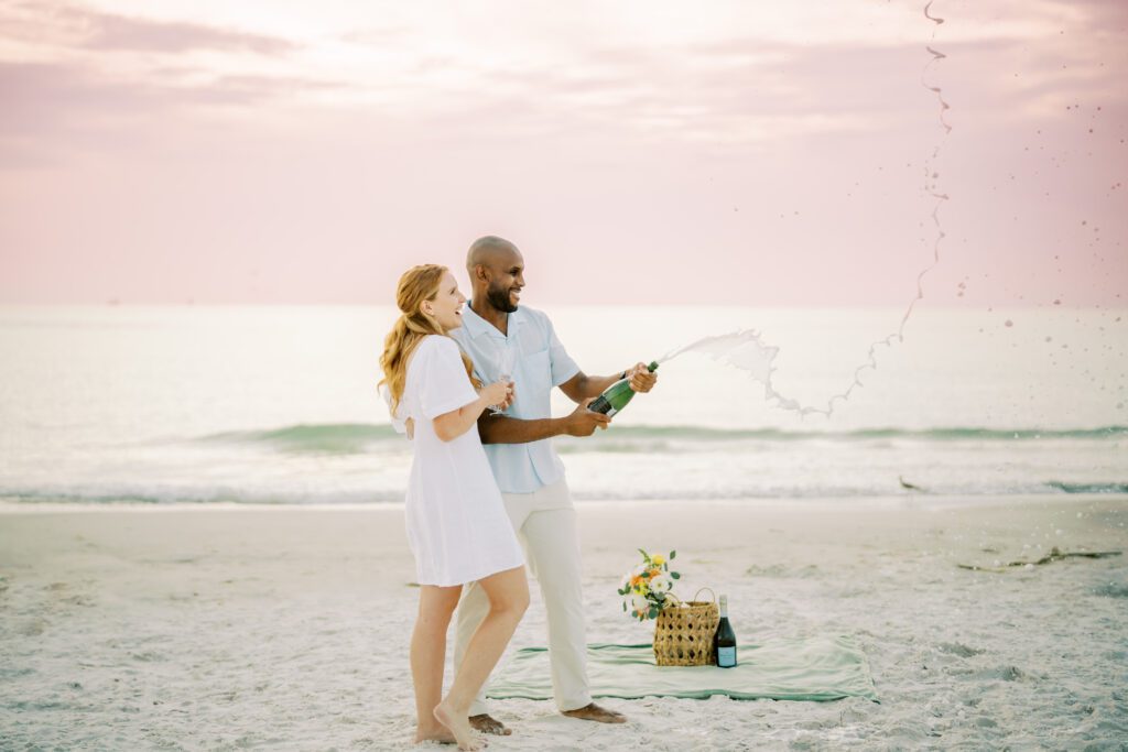 Tampa Engagement at Fort de soto beach Bride and groom popping champagne at sunset 
