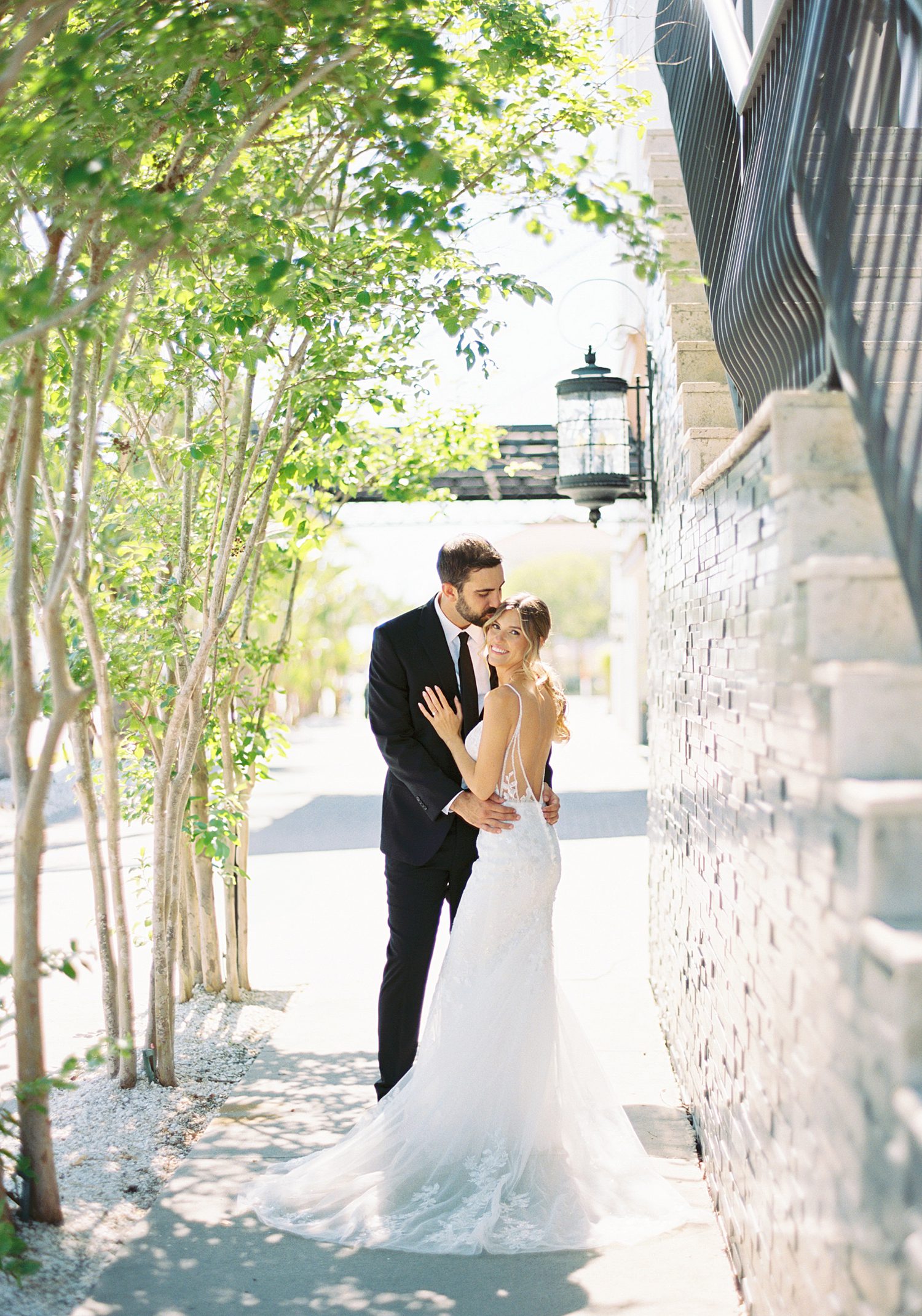 bride and groom kiss on sidewalk outside the Hotel Zamora