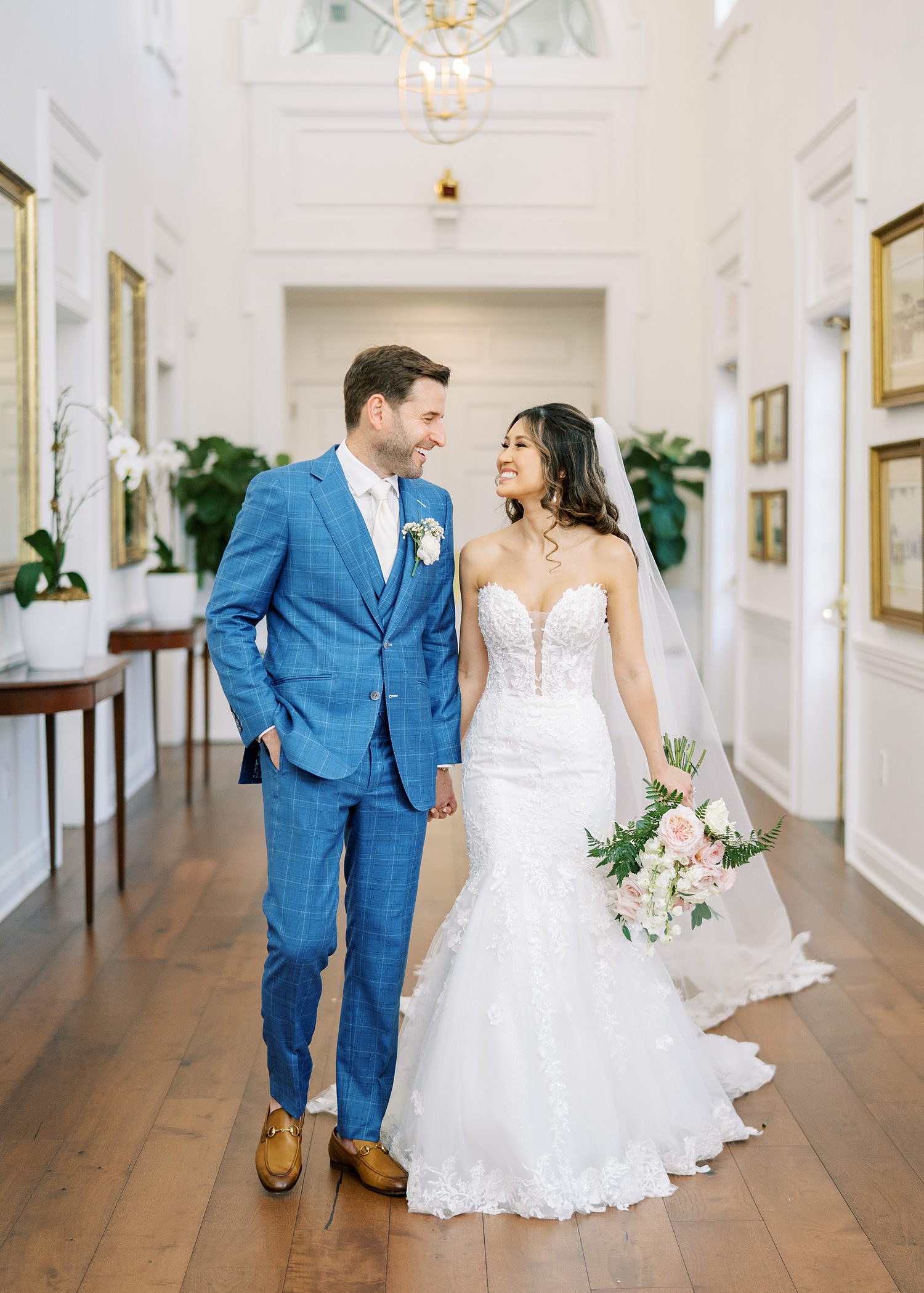 bride and groom hold hands walking through hallway of Tampa Yacht and Country Club