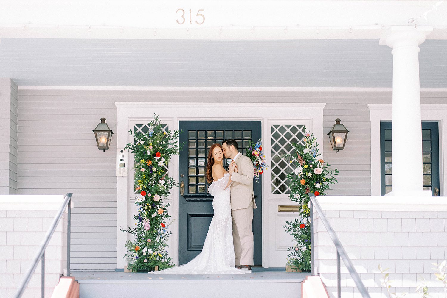 bride and groom hug in front of front door at the Orlo House & Ballroom